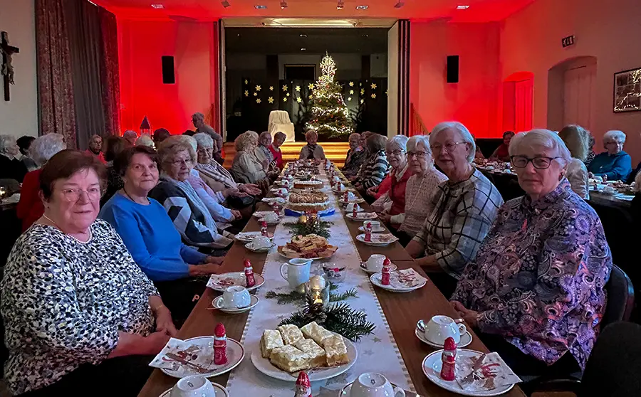 Gäste sitzen an adventlicher Tafel