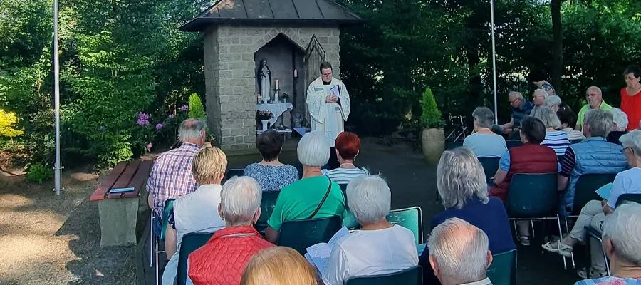 Foto der Andacht mit Pfarrer Kickum und Gläubigen an der Kapelle