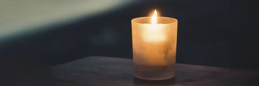 Kerze im Glas leuchtet im Dunklen