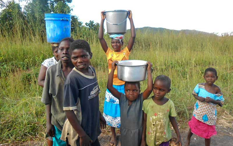 Kindergruppe mit Wasser in Töpfen