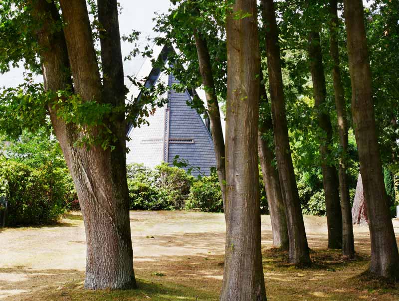 Blick durch die Baeume auf Kapelle